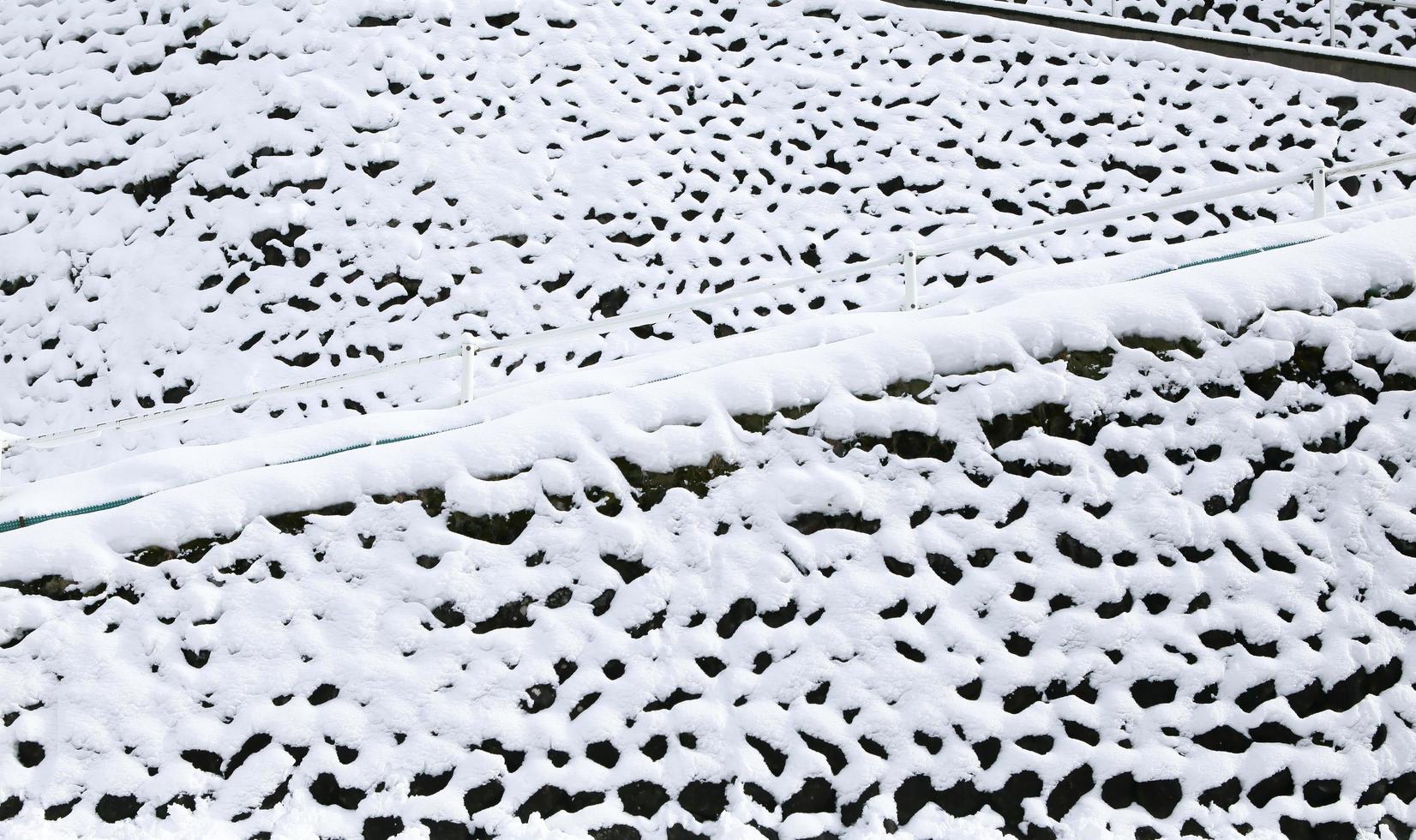 stone wall covered with snow i photo