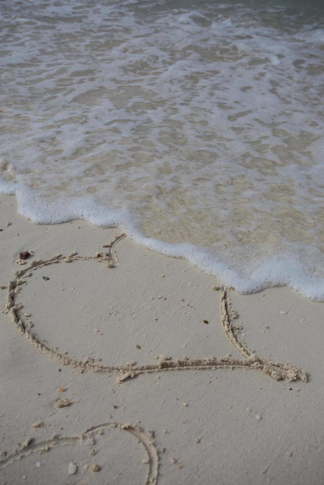 hearts drawn on the sand of a beach photo