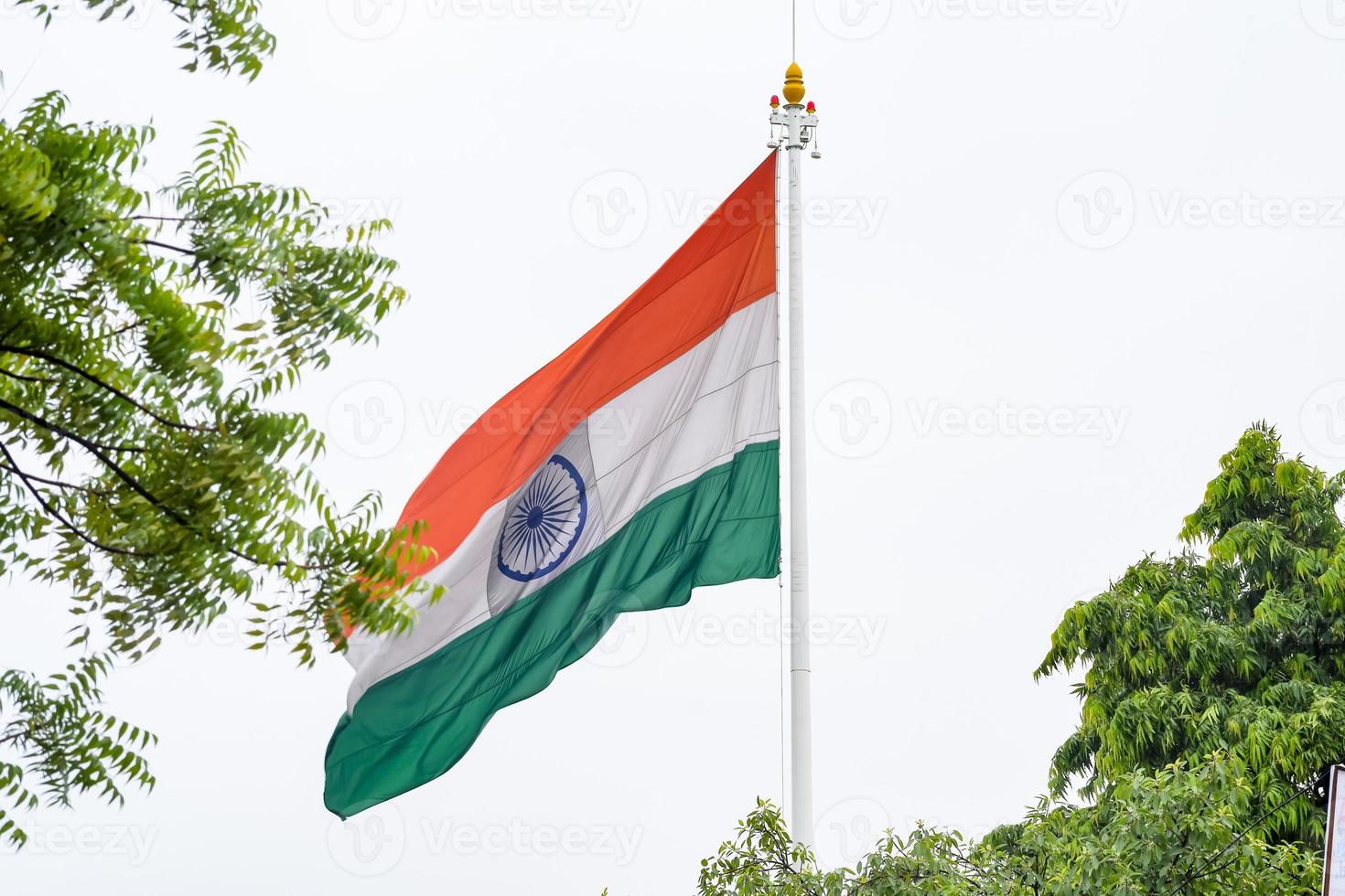 India flag flying high at Connaught Place with pride in blue sky, India flag fluttering, Indian Flag on Independence Day and Republic Day of India, tilt up shot, Waving Indian flag, Har Ghar Tiranga photo