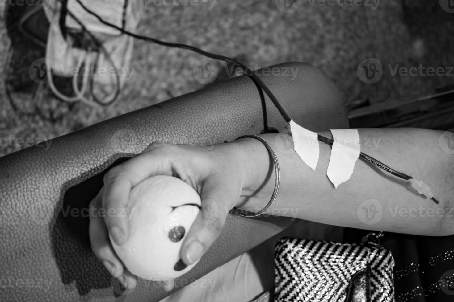 Blood donor at Blood donation camp held with a bouncy ball holding in hand at Balaji Temple, Vivek Vihar, Delhi, India, Image for World blood donor day on June 14 every year, Blood Donation Camp photo