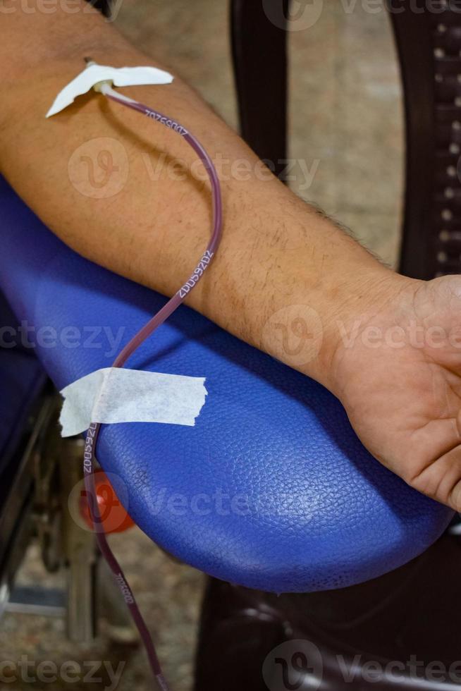 Blood donor at Blood donation camp held with a bouncy ball holding in hand at Balaji Temple, Vivek Vihar, Delhi, India, Image for World blood donor day on June 14 every year, Blood Donation Camp photo
