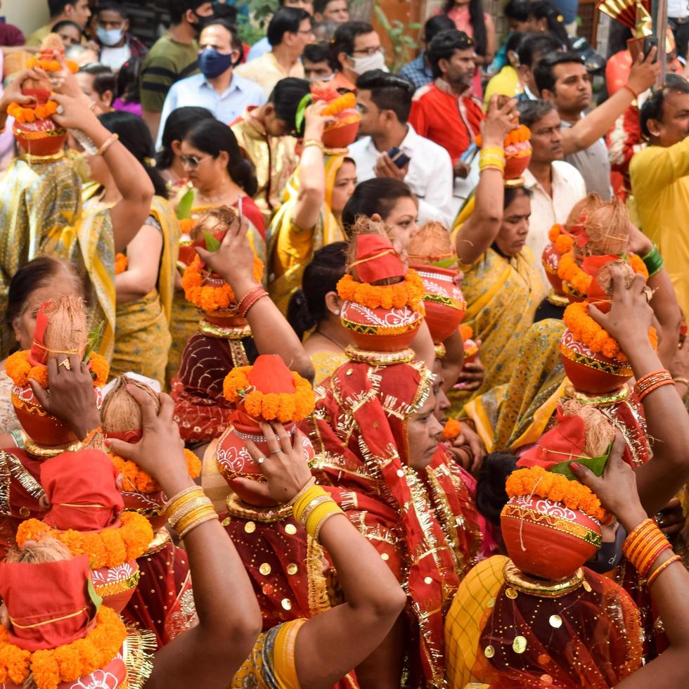 New Delhi, India April 03 2022 - Women with Kalash on head during Jagannath Temple Mangal Kalash Yatra, Indian Hindu devotees carry earthen pots containing sacred water with a coconut on top photo