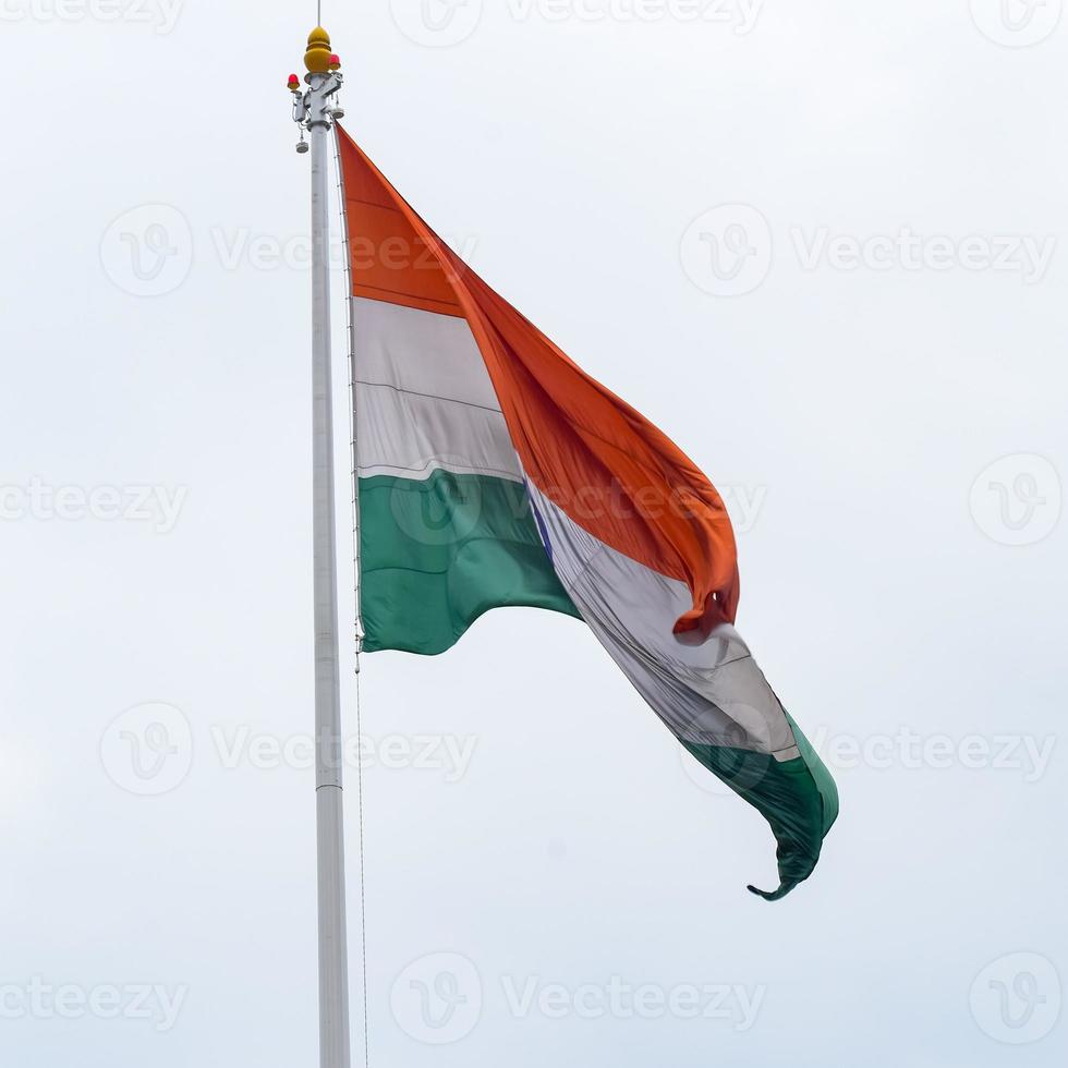 India flag flying high at Connaught Place with pride in blue sky, India flag fluttering, Indian Flag on Independence Day and Republic Day of India, tilt up shot, Waving Indian flag, Har Ghar Tiranga photo