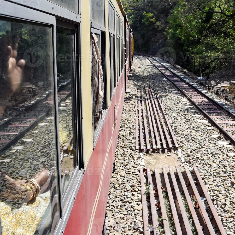 Toy Train moving on mountain slopes, beautiful view, one side mountain, one side valley moving on railway to the hill, among green natural forest. Toy train from Kalka to Shimla in India, Indian Train photo