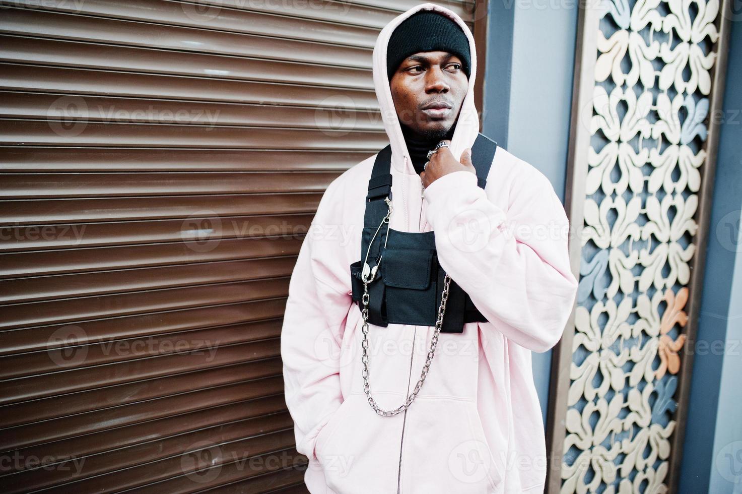 Stylish urban style african american man in pink hoodie posed. Afro rapper guy. photo