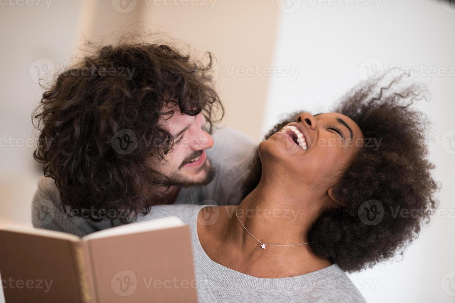 multiethnic couple hugging in front of fireplace photo