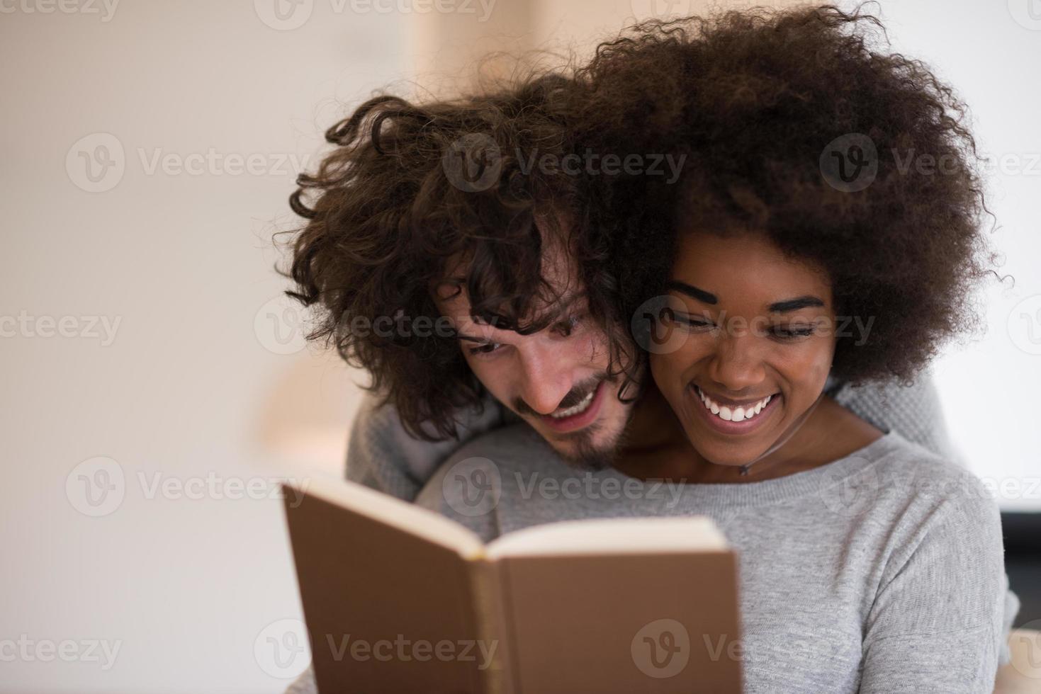 multiethnic couple hugging in front of fireplace photo