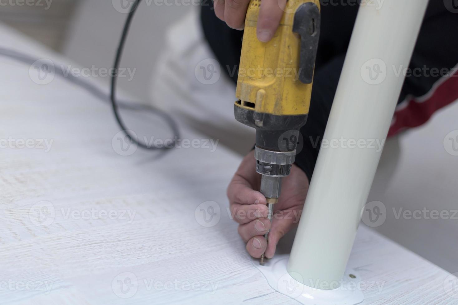 repairman working with drilling machine photo