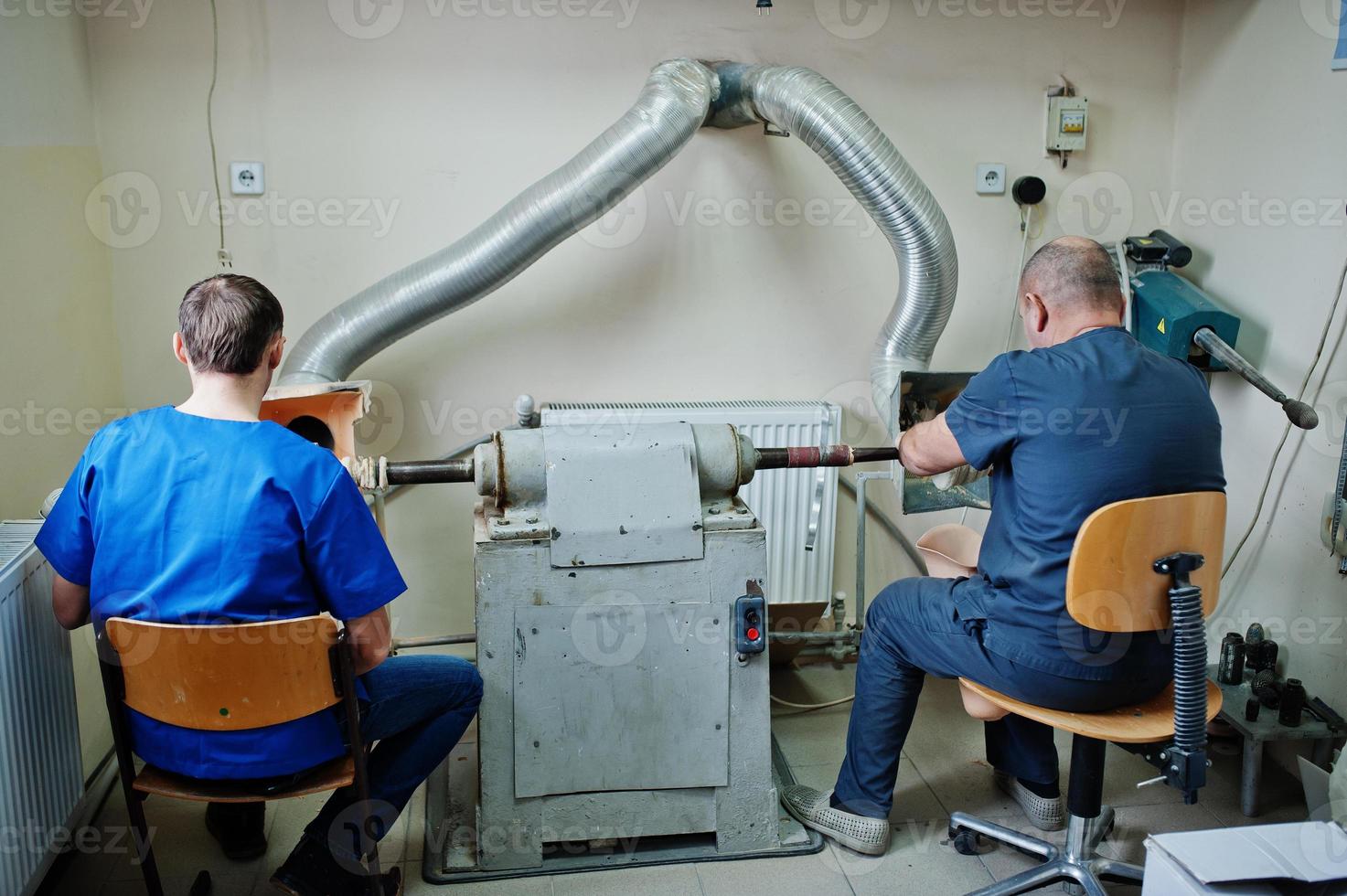 dos trabajadores protésicos que fabrican una pierna protésica mientras trabajan en el laboratorio. foto