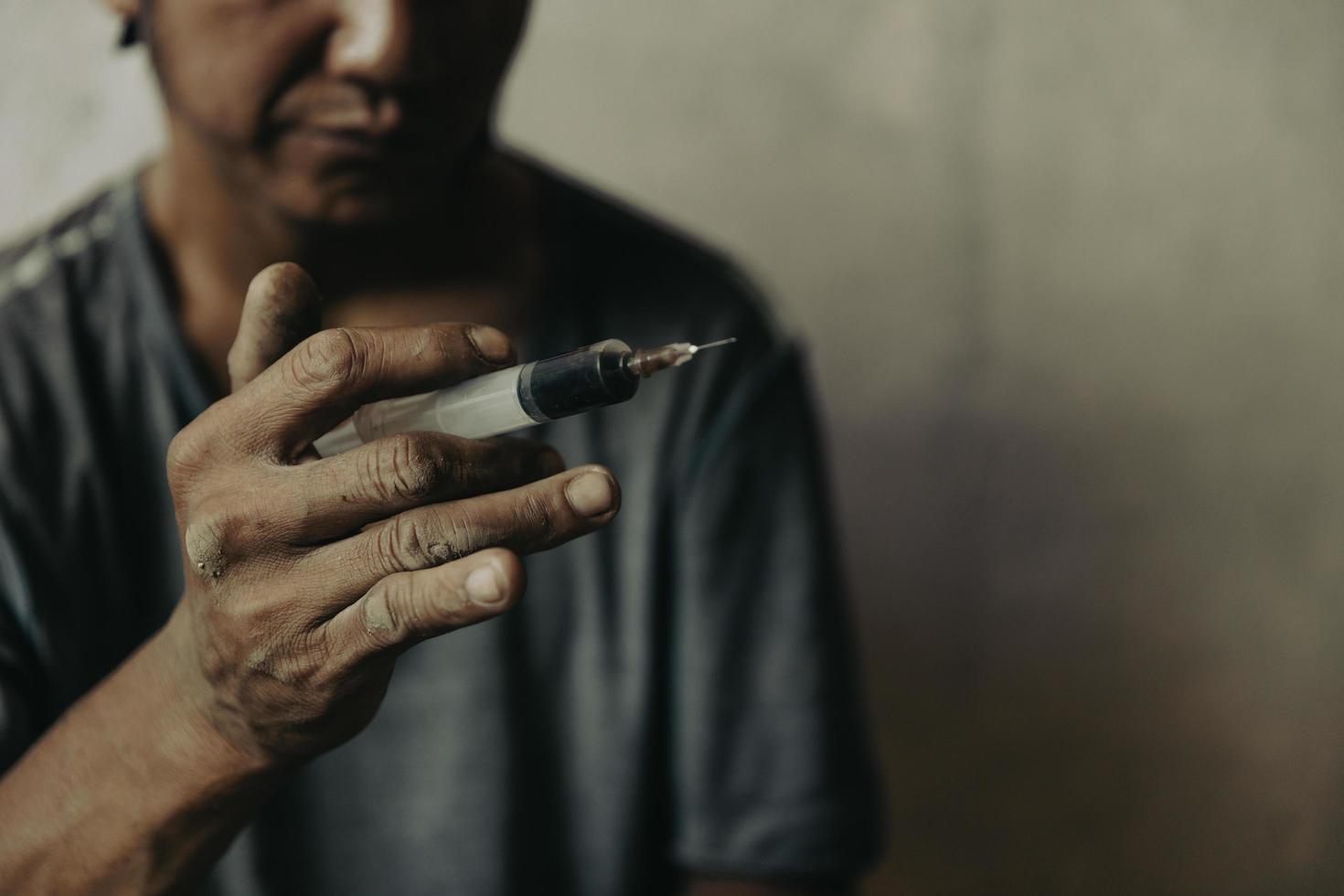 A heroin syringe in the hand of a drug addict. Drug concept. International drug abuse day. photo