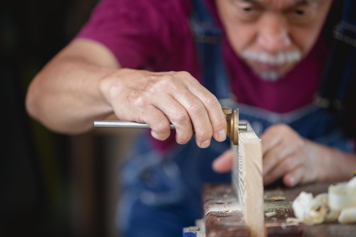 A man works in a carpentry shop. Carpenter working on woodworking machines in carpentry shop. photo