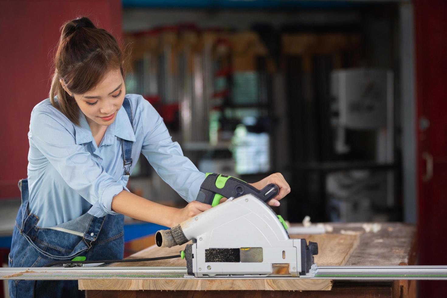 woman works in a carpentry shop. Carpenter working on woodworking machines in carpentry shop. photo