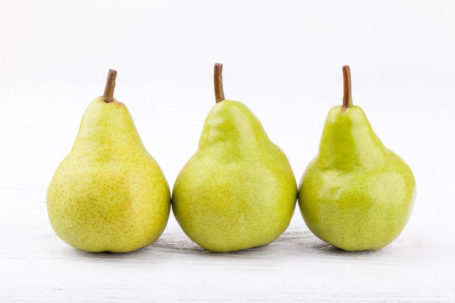 green pears on white wooden background photo