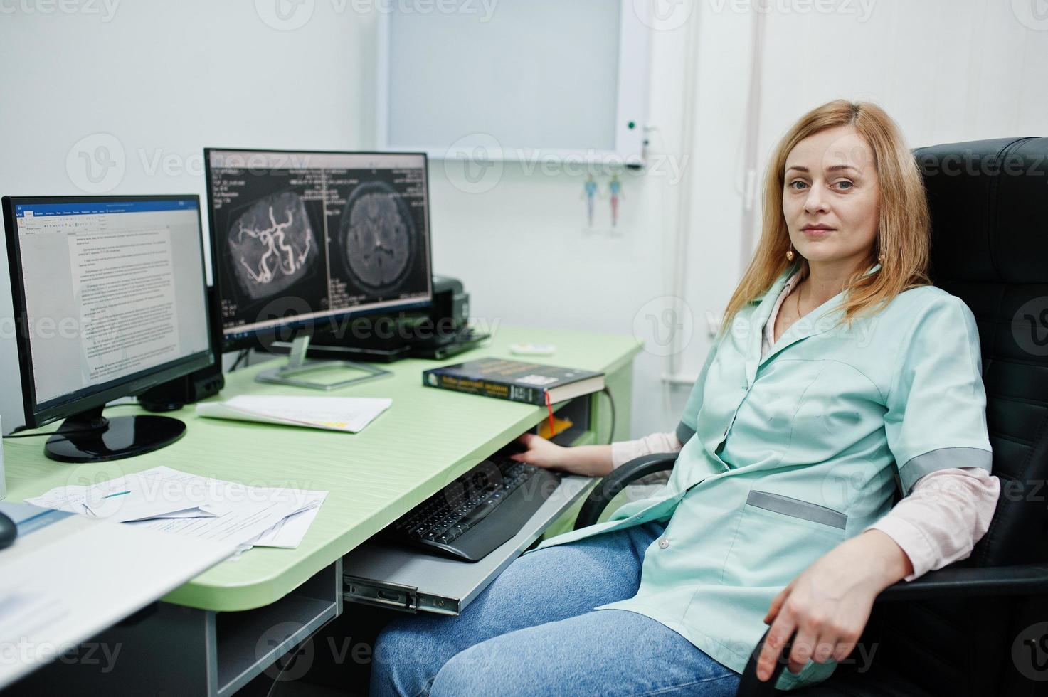 tema medico médico en la oficina de resonancia magnética en el centro de diagnóstico en el hospital, sentado cerca de monitores de computadora. foto