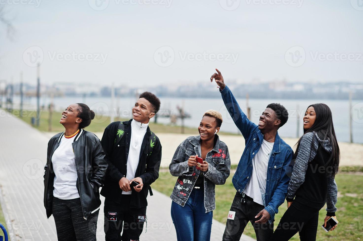 Young millennials african friends walking in city. Happy black people having fun together. Generation Z friendship concept. photo