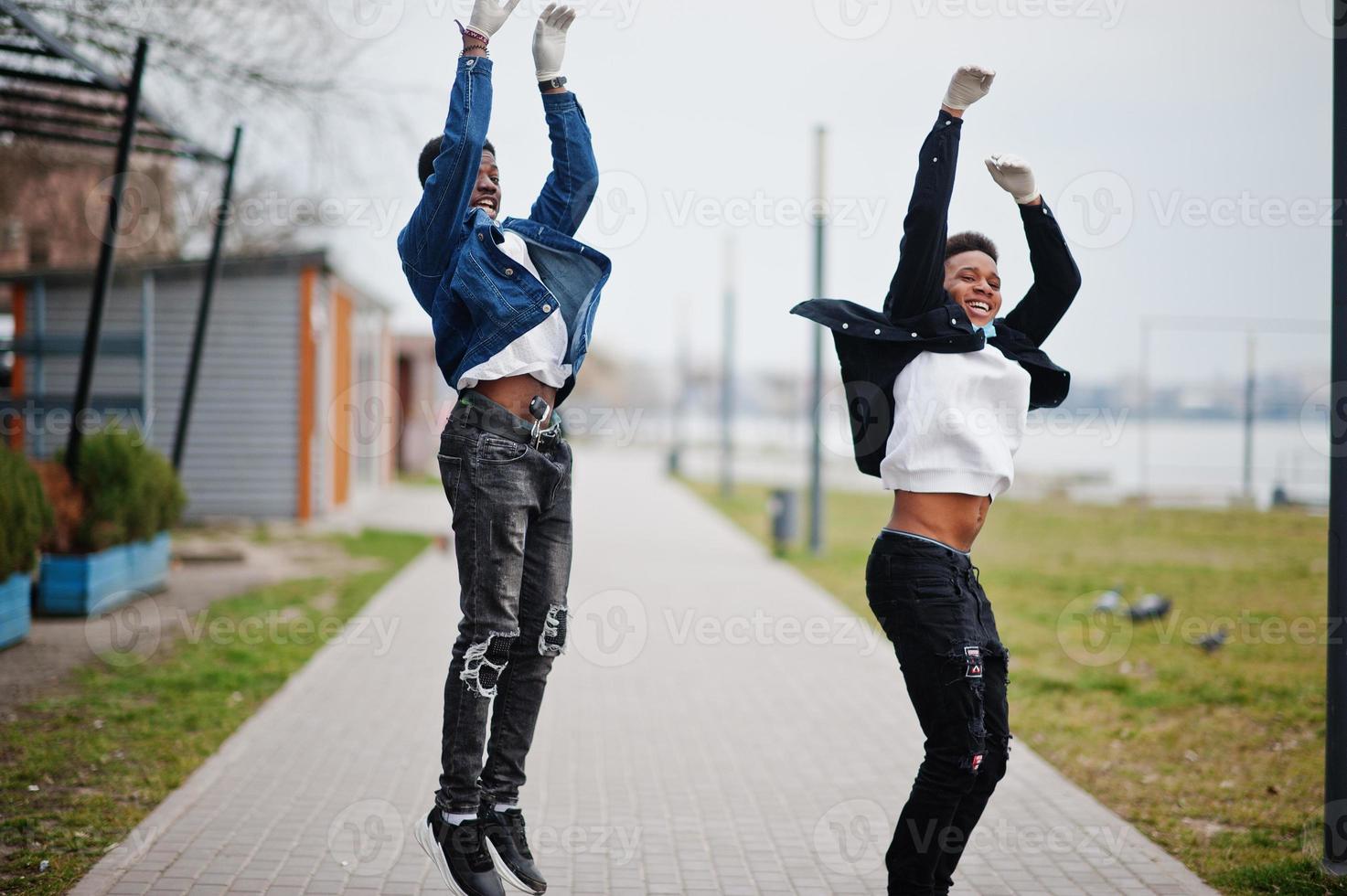 dos amigos adolescentes africanos en el parque que usan máscaras médicas protegen de infecciones y enfermedades cuarentena del virus del coronavirus. foto