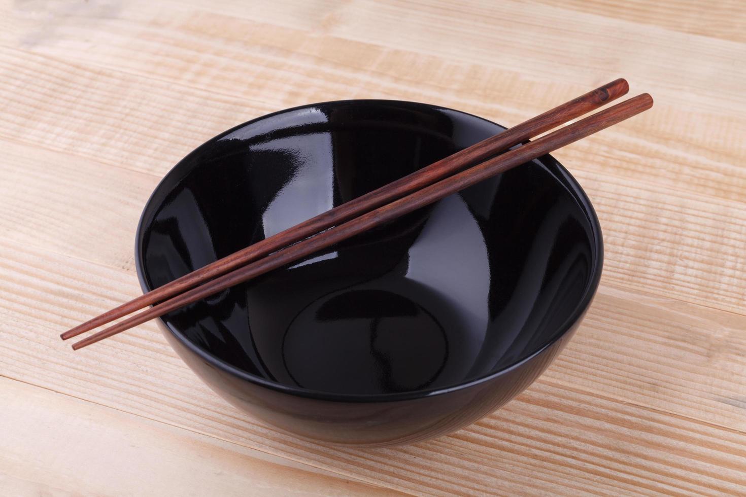 Chopsticks in asian set table on wood background photo