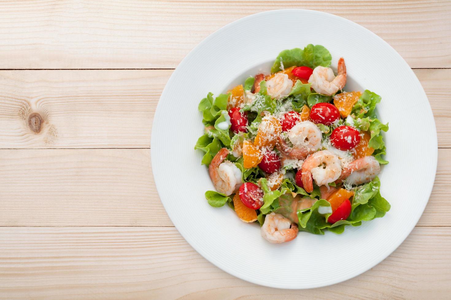 Grilled shrimp salad on wood table, Top view photo