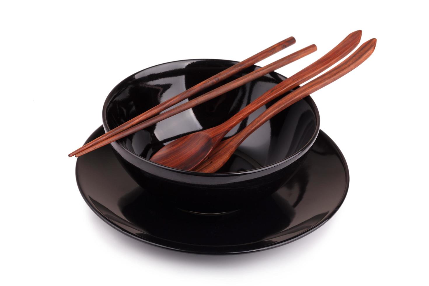 Black ceramic bowl and wooden spoon and chopsticks photo