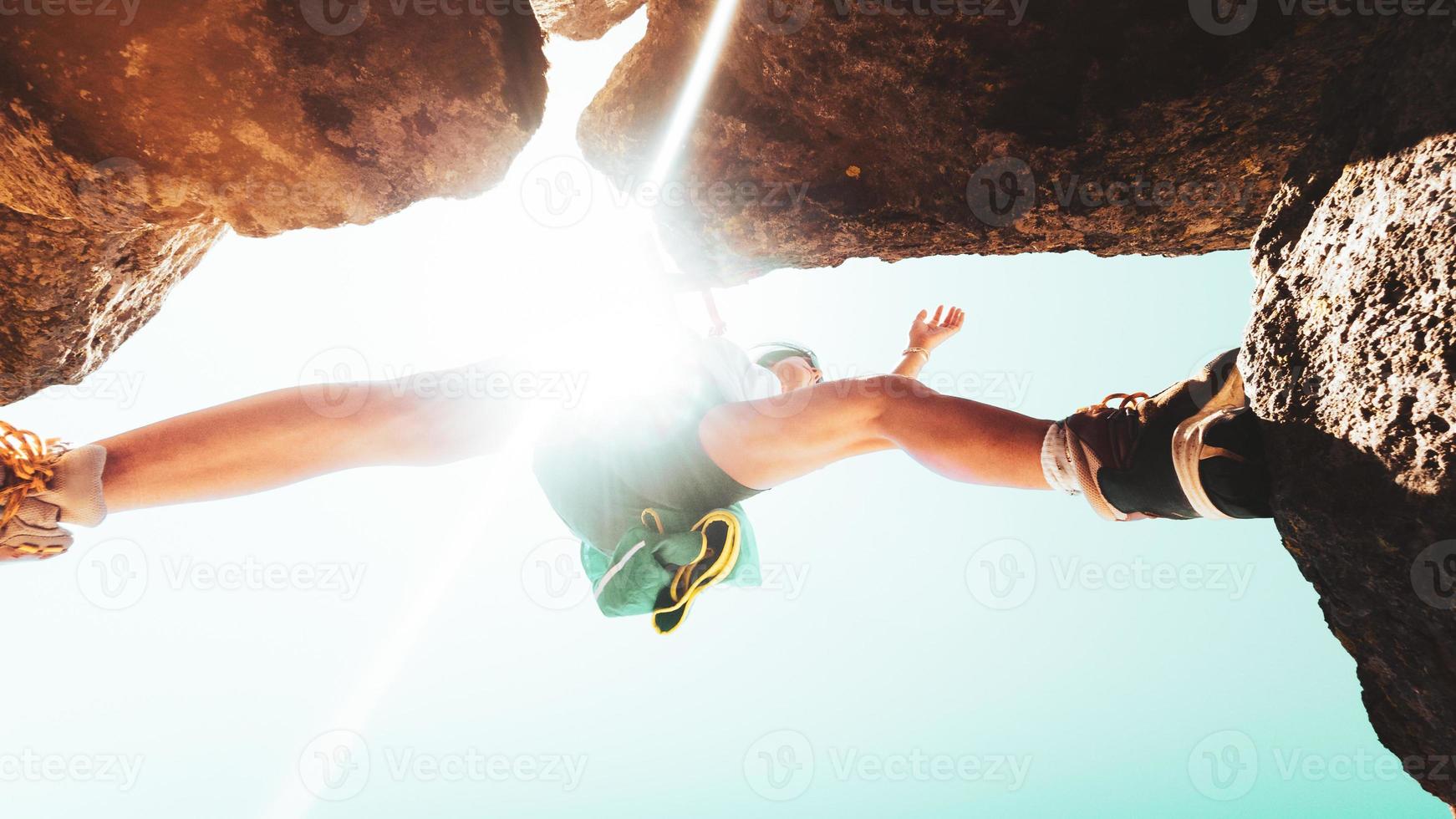 Low angle close up young caucasian sporty woman training steps on rock climb outdoors in sunny hot weather alone. Inspirational active strong woman sports activities outdoors photo