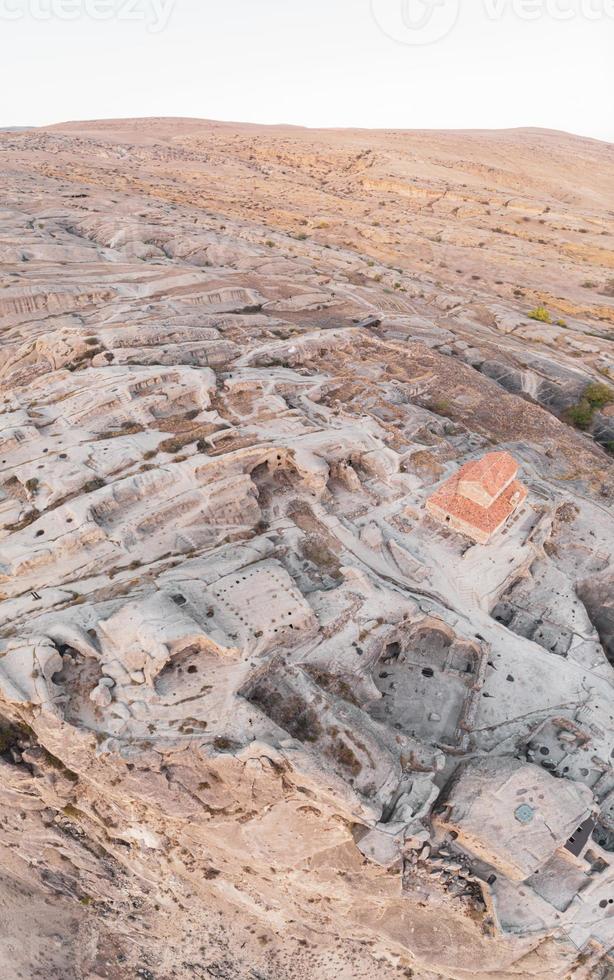 Panoramic view to Uplistsiche cave town caves with basilica in the middle and scenic rocky landscape. Blank space travel background. photo