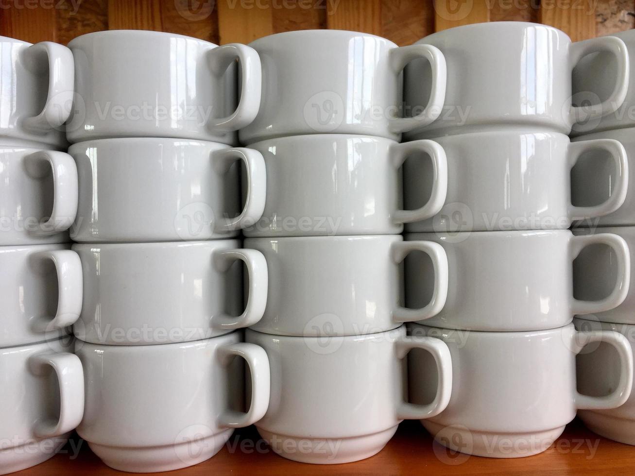 the arrangement of ceramic glasses neatly lined up on a shelf photo