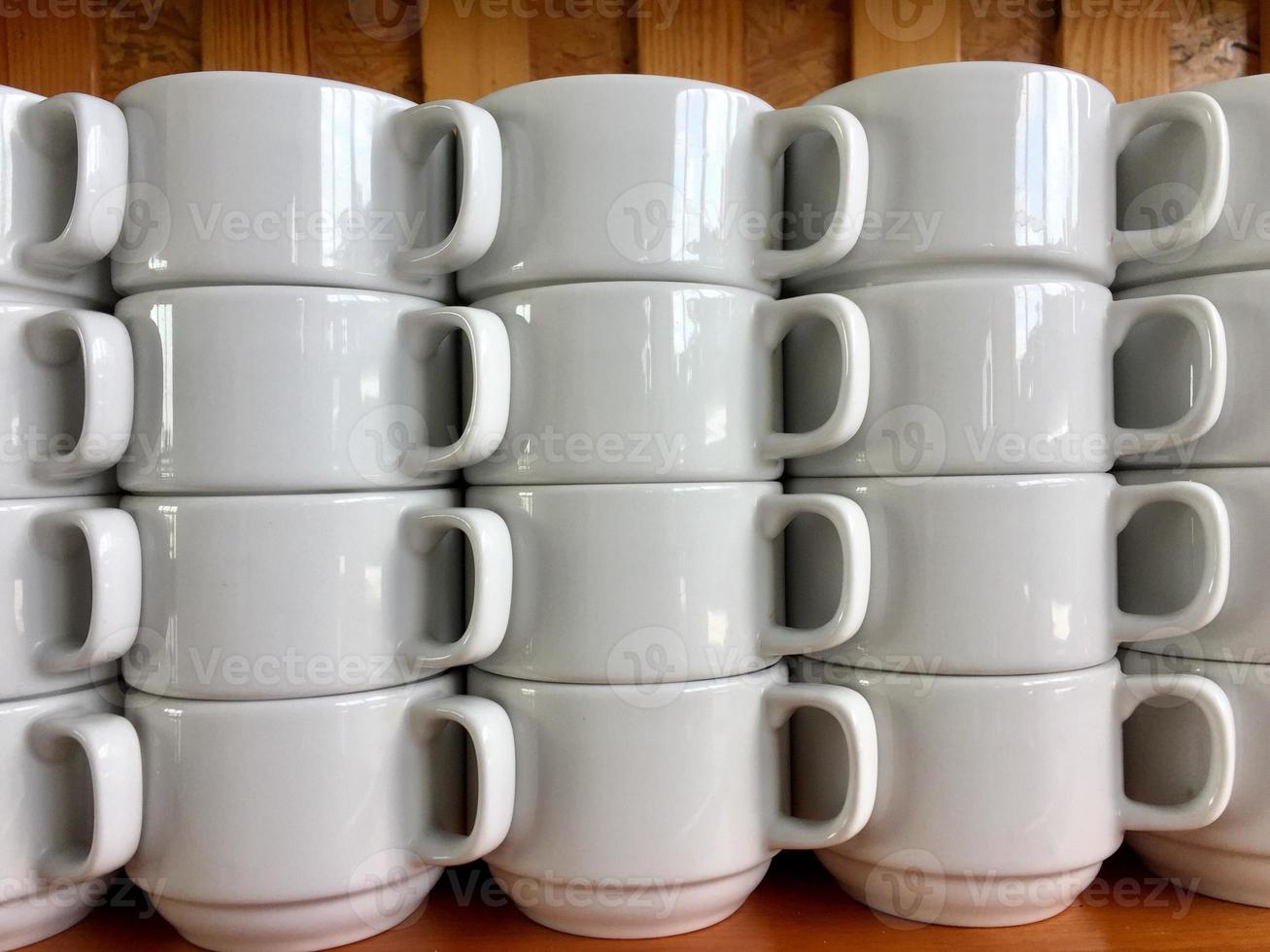 the arrangement of ceramic glasses neatly lined up on a shelf. photo