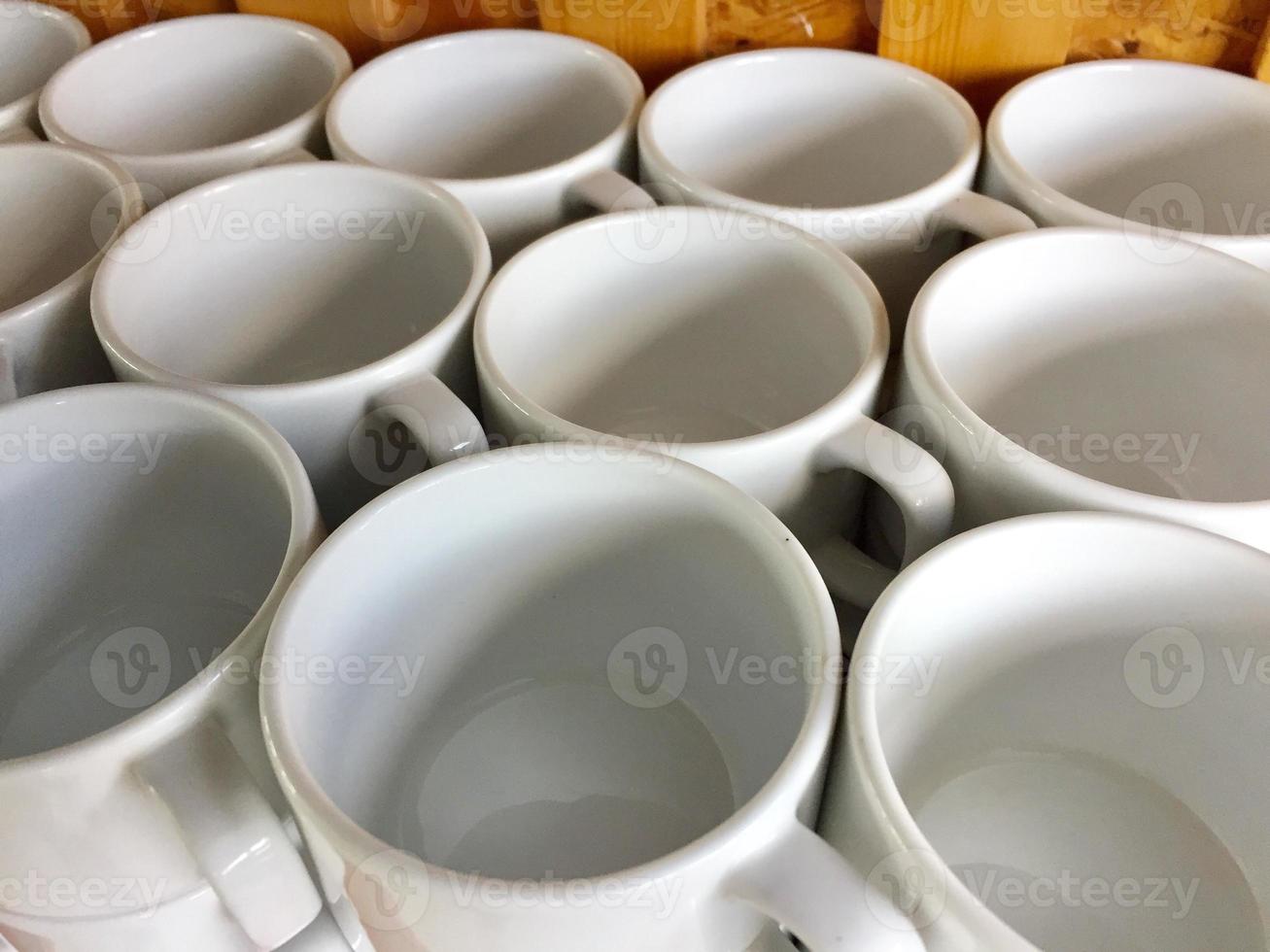 the arrangement of ceramic glasses neatly lined up on a shelf. photo