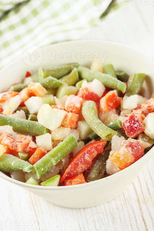 Mixture of frozen vegetables in white bowl photo