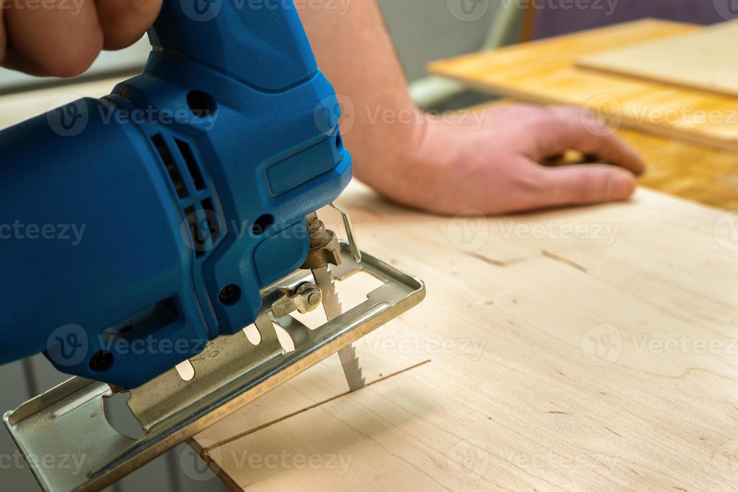 Image of a man hand using electric jigsaw photo