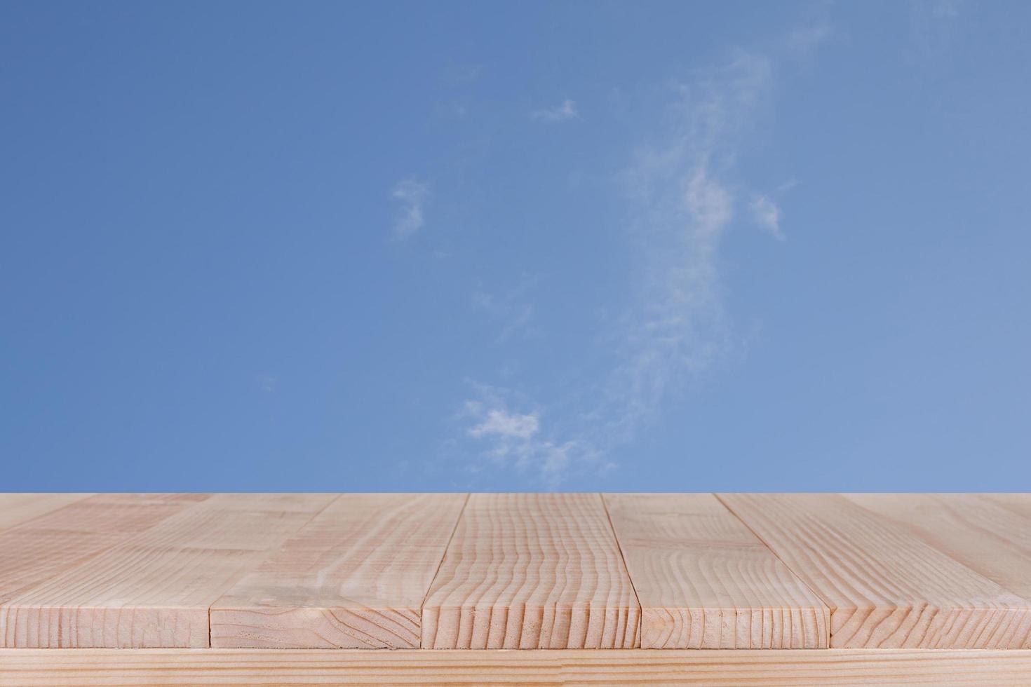 brown wood table top on blue sky with cloud background - can be used for montage or display your products photo