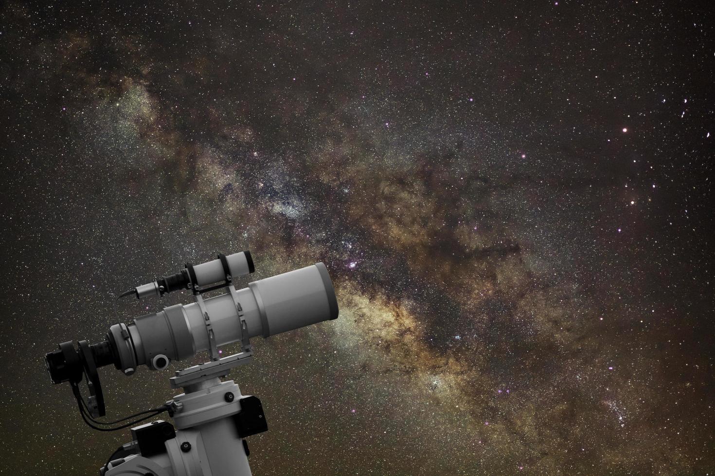 telescopio observando la galaxia de la vía láctea en el cielo nocturno foto