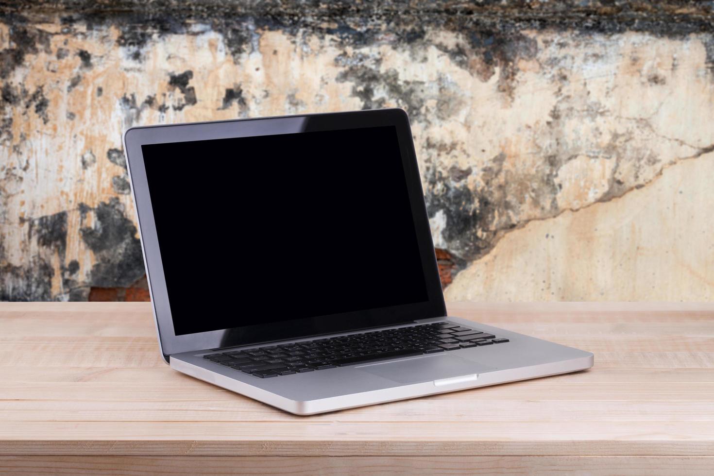 Front view of the laptop is on the work table concrete background photo