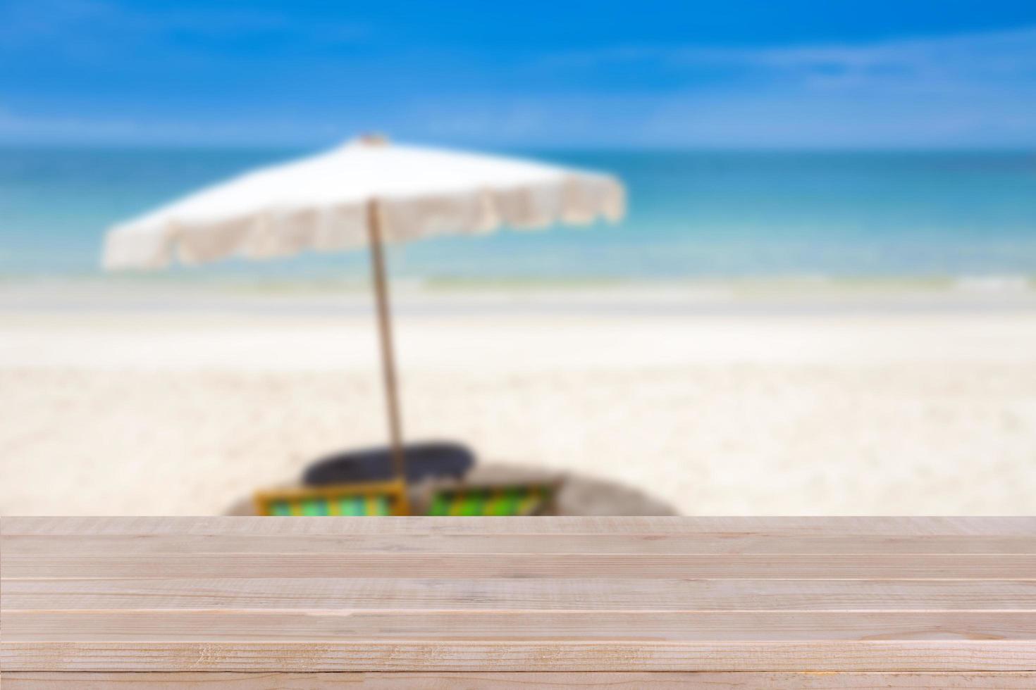 Wood table top on blurred blue sea and white sand beach background photo