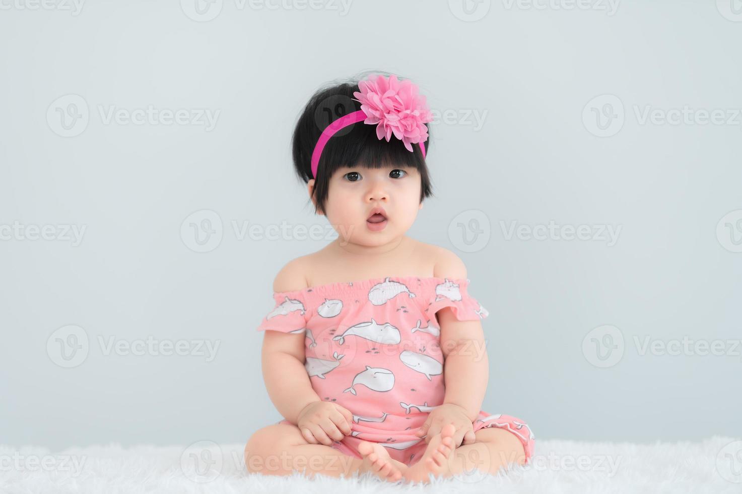 retrato de lindo bebé asiático en alfombra blanca, sonrisa recién nacida para tomar una foto
