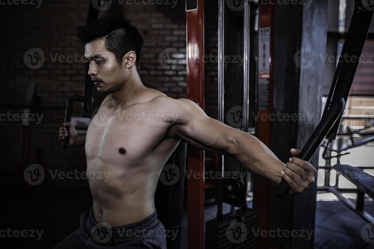 retrato de hombre asiático con gran músculo en el gimnasio, gente de tailandia, entrenamiento para una buena salud, entrenamiento de peso corporal, fitness en el concepto de gimnasio foto