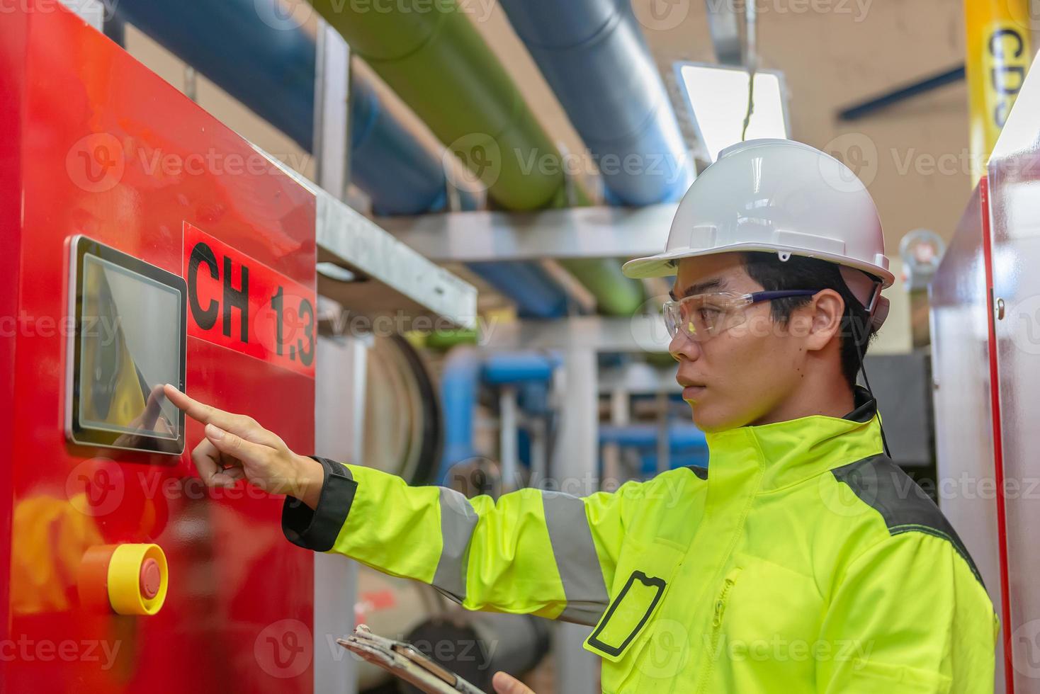 Asian engineer wearing glasses working in the boiler room,maintenance checking technical data of heating system equipment,Thailand people photo