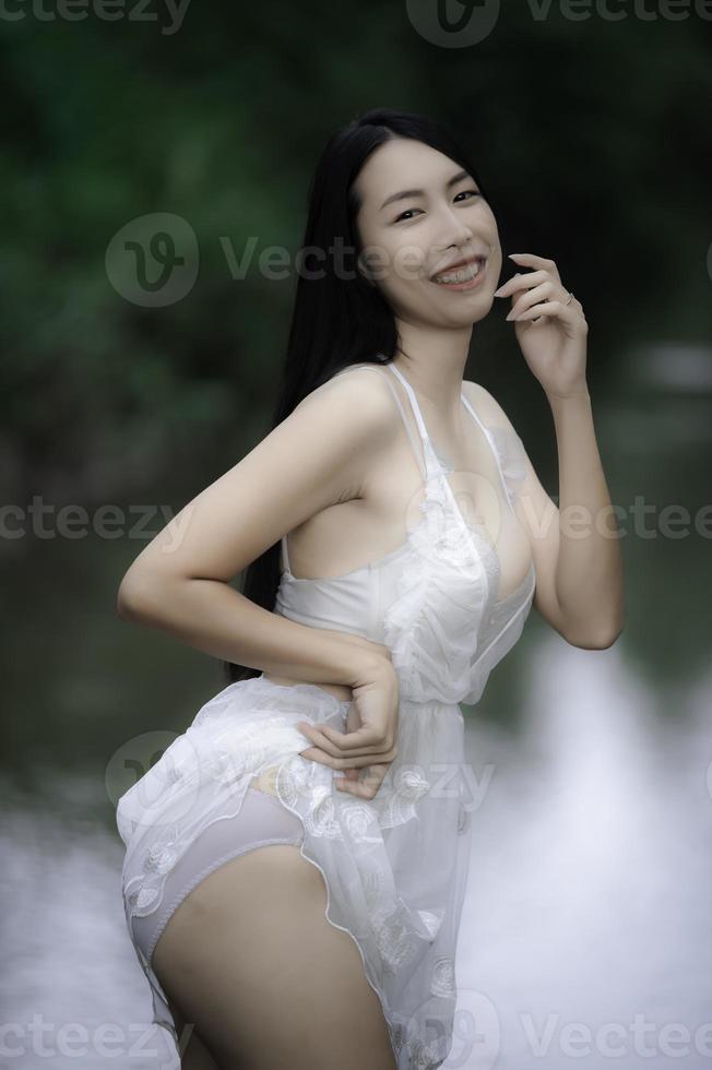 Portrait of sexy asian woman at the waterfall,Feeling fresh at the river,Thai female relax at country photo