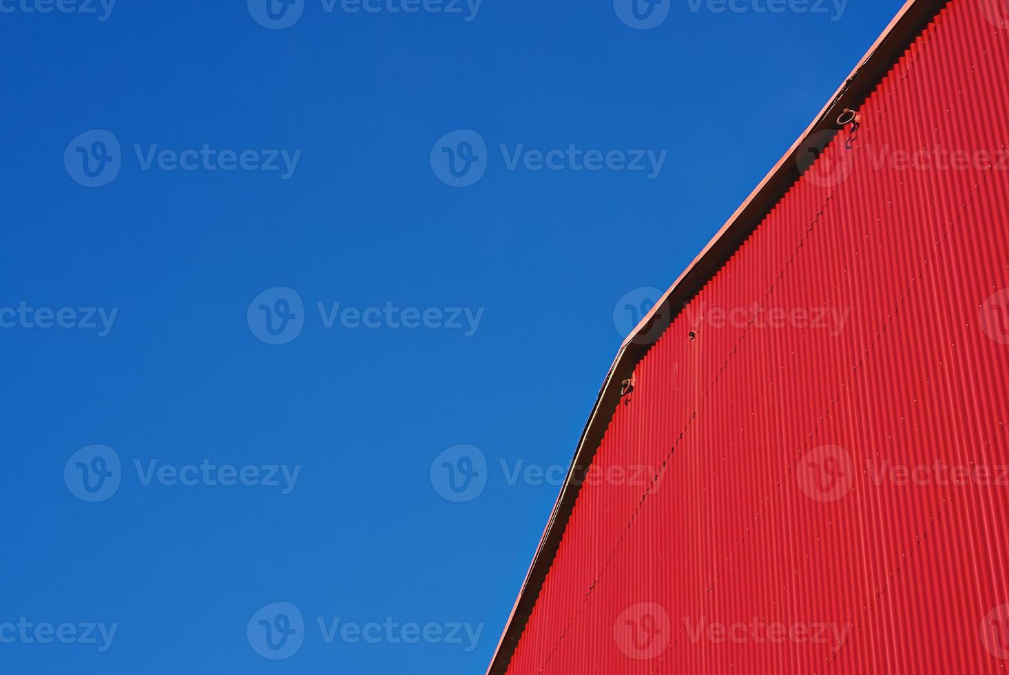 Urban Abstract minimalism. Red building facade with metal siding on blue sky, nobody photo