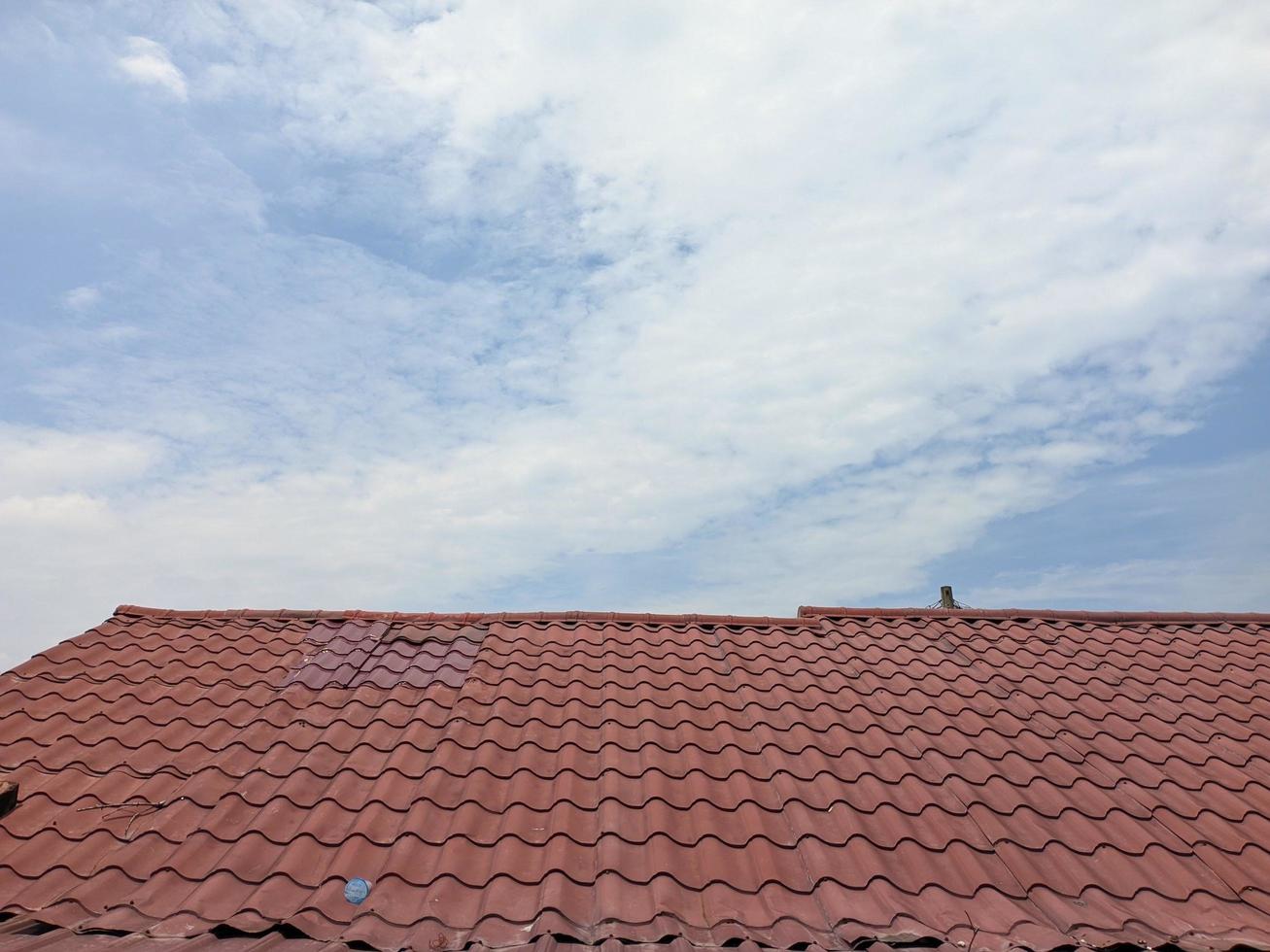 el techo de la casa con el cálido sol y el cielo azul brillante foto