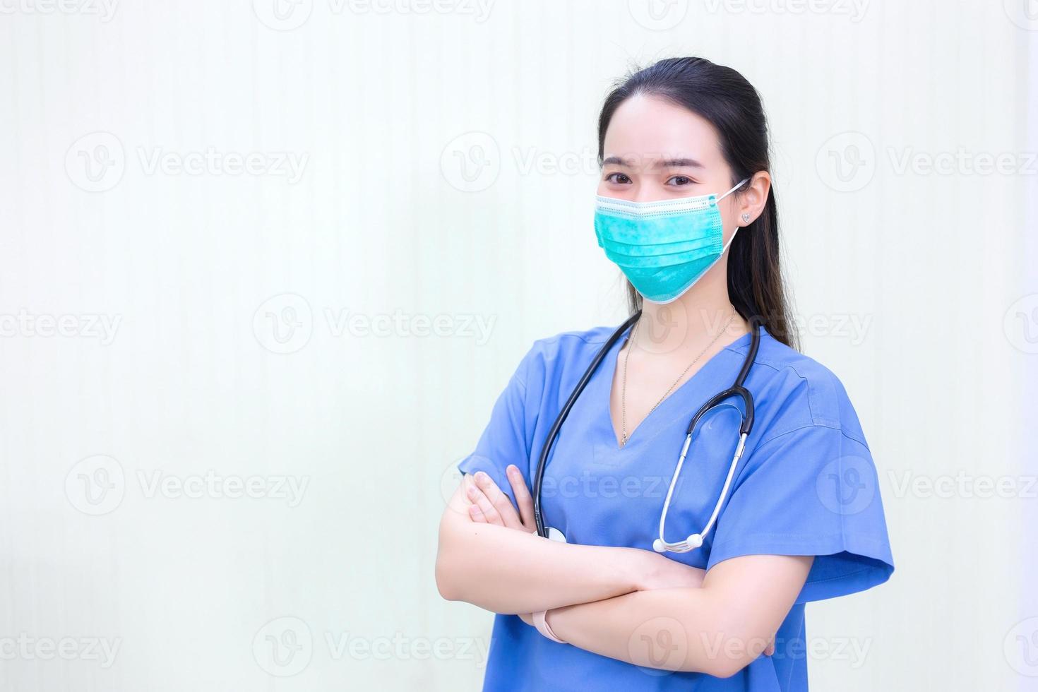 el médico asiático usa un abrigo médico con estetoscopio y mascarilla médica para proteger el sistema respiratorio del patógeno en un nuevo concepto normal. foto