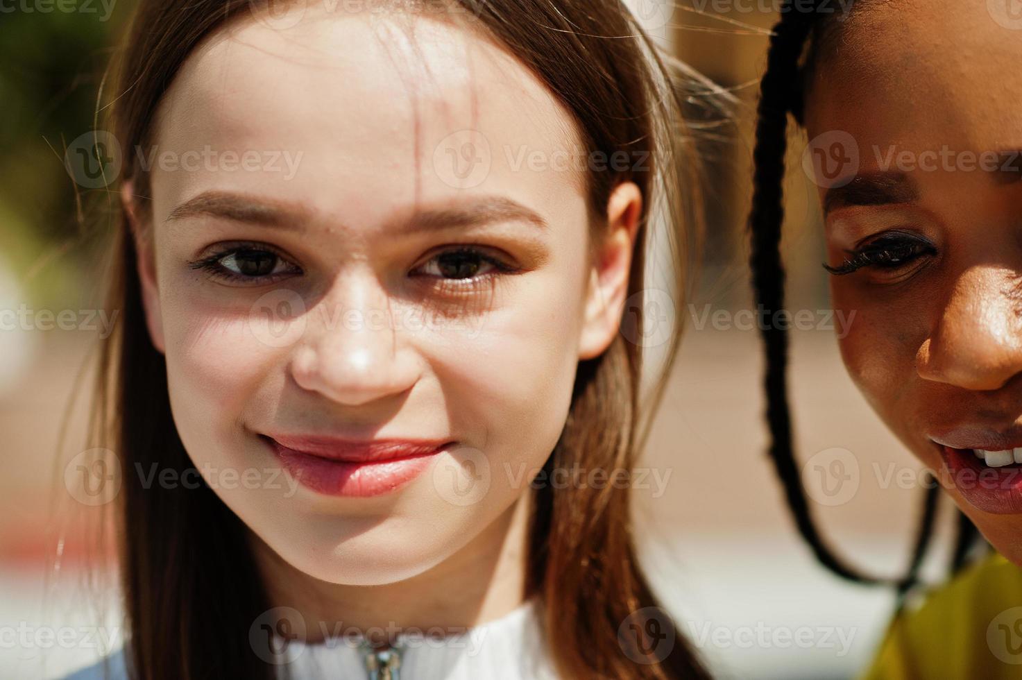Close up faces of white caucasian girl and black African American together. World unity, racial love, understanding in tolerance and races diversity cooperation. photo