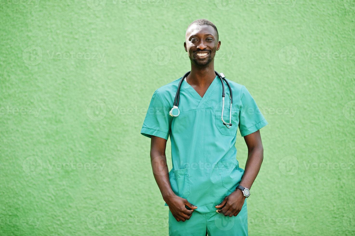 Portrait of African male doctor with stethoscope wearing green coat. photo