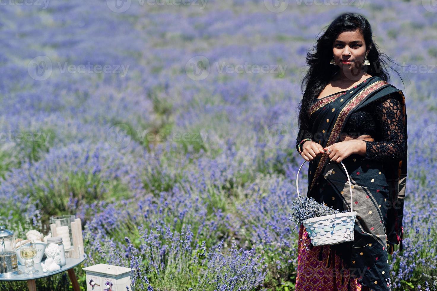 Beautiful indian girl wear saree india traditional dress in purple lavender field. photo