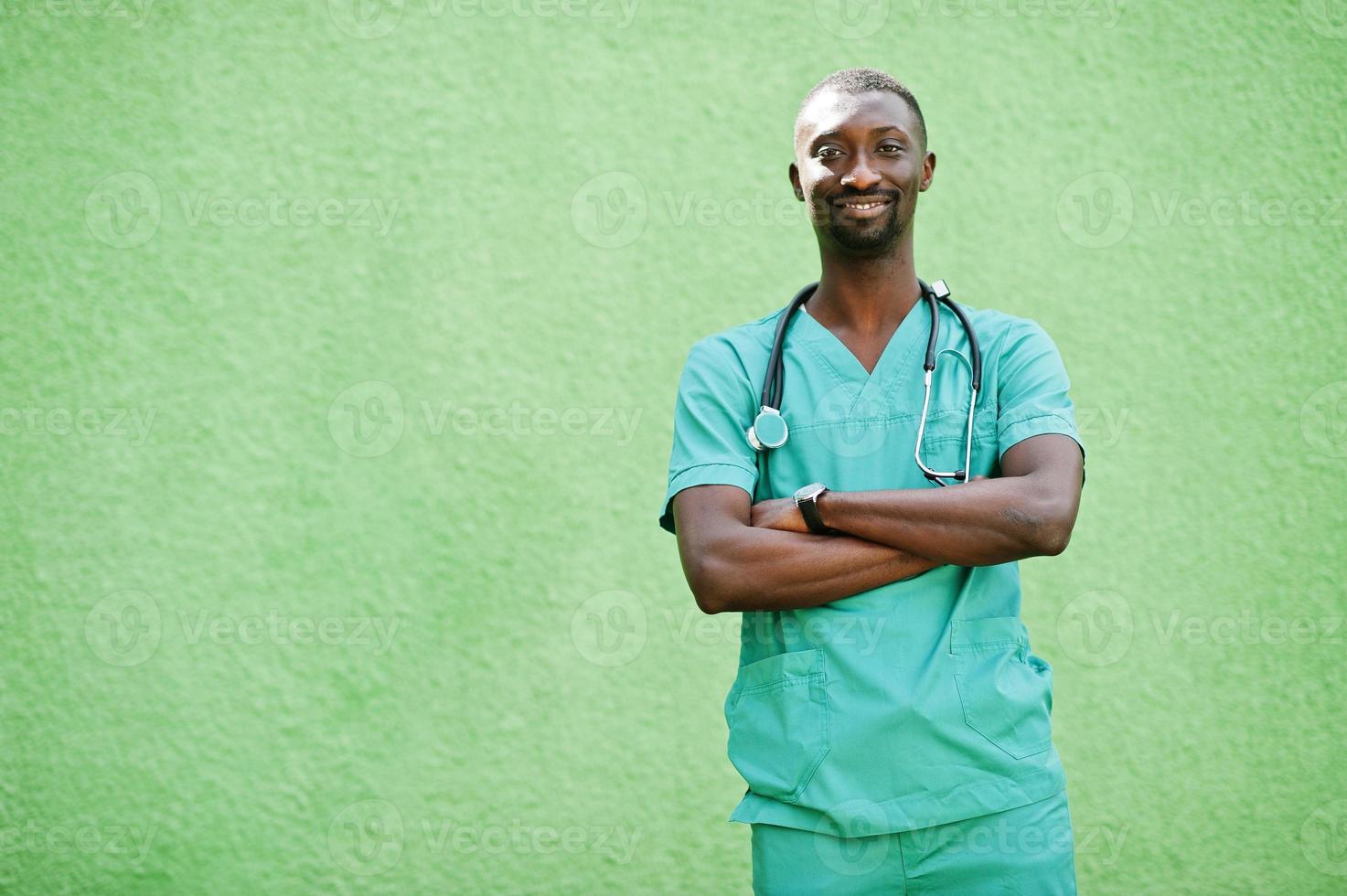 Portrait of African male doctor with stethoscope wearing green coat. photo