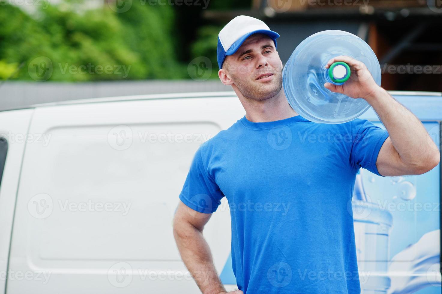 Delivery man in front cargo van delivering bottles of water. photo