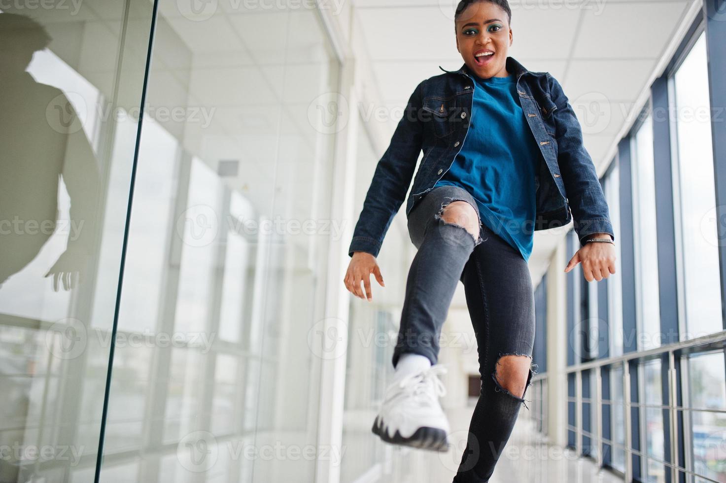 mujer africana con chaqueta de jeans posada en el interior. foto