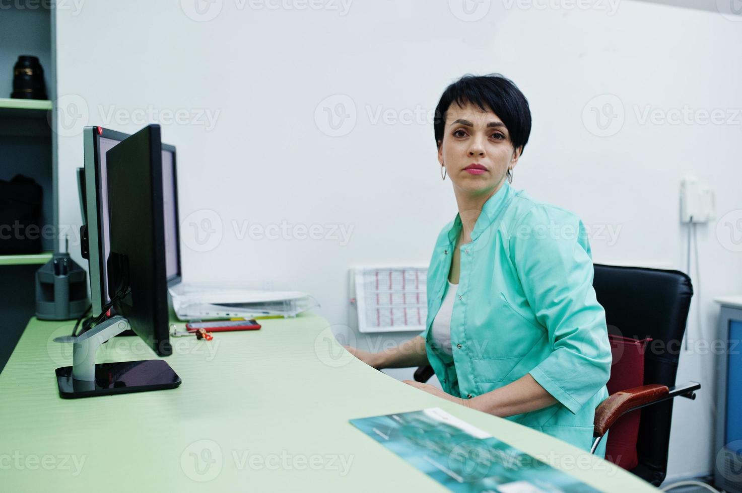 Medical theme. Doctor in the mri office at diagnostic center in hospital, sitting near monitors of computer. photo