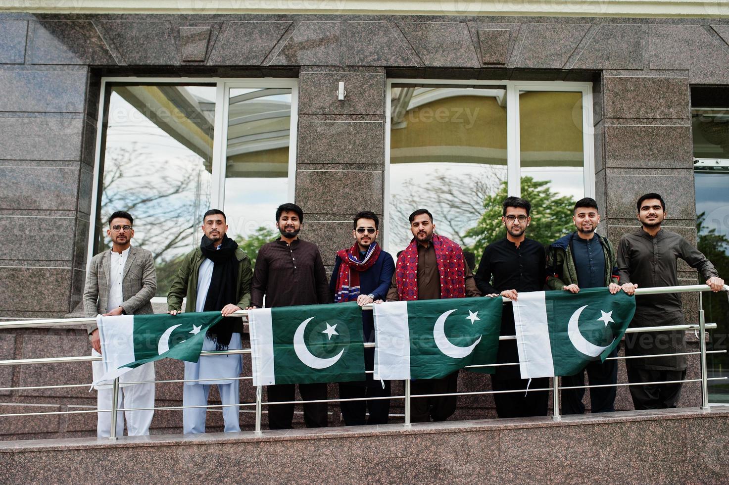 Group of pakistani man wearing traditional clothes salwar kameez or kurta with Pakistan flags. photo
