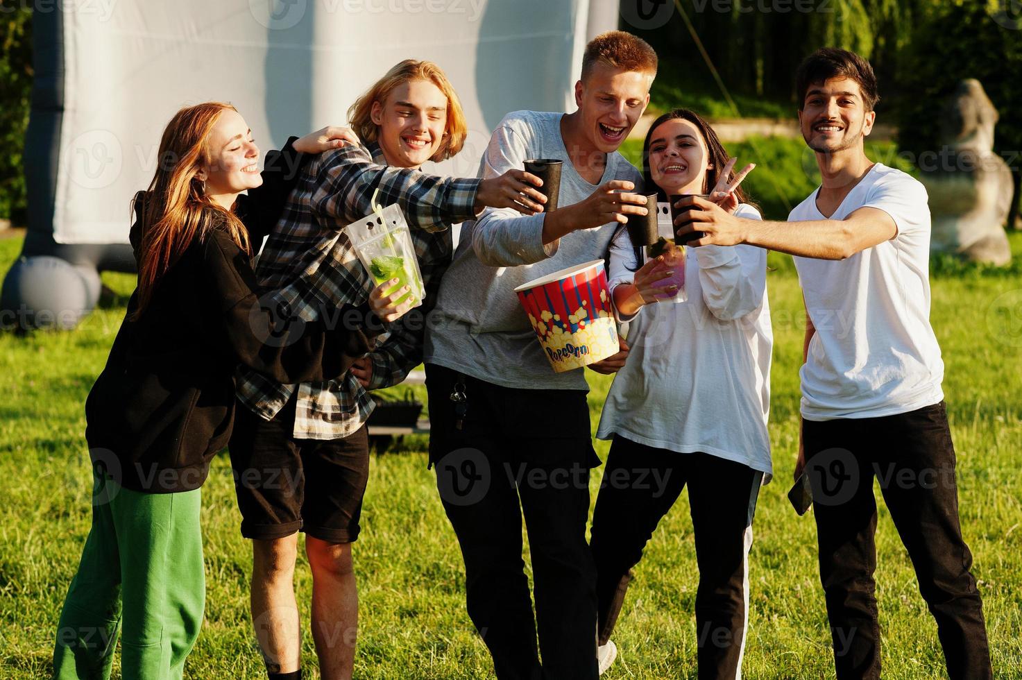 joven grupo multiétnico de personas viendo películas en poof en cine al aire libre. foto